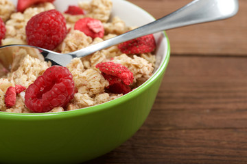 musli with fresh raspberry on wooden background