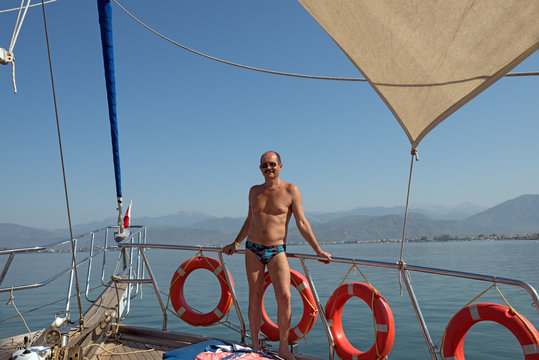 Mature man is on the deck of the yacht.