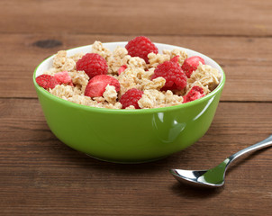 musli with fresh raspberry on wooden background