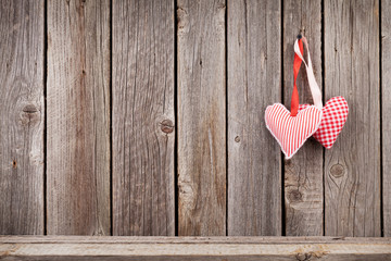 Two Valentines day hearts on rustic wooden wall