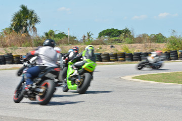 Fototapeta premium Niewyraźni sportowcy uprawiający motocykle wyścigowe na torze wyścigowym