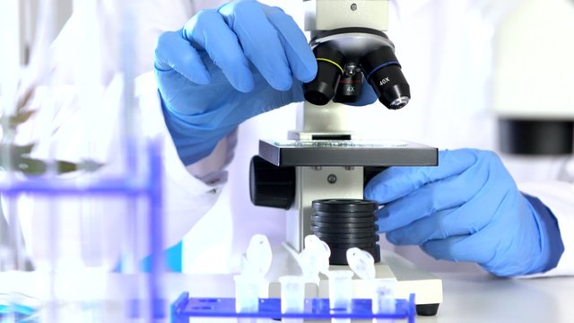 Researcher Working in Lab With Microscope.researcher in biochemical lab