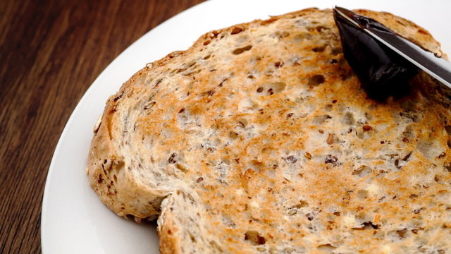 Spreading Australian Vegemite on whole wheat toast in slow motion