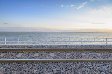 railway or railroad crossing to the lake with the morning light