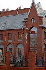 red gothic building housing type with a statue on the facade