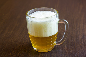 Mug of beer on wooden background