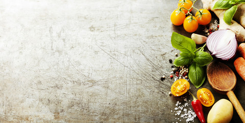 Wooden spoon and fresh organic vegetables on old background