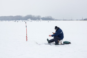 Fototapeta na wymiar fisherman on ice in winter