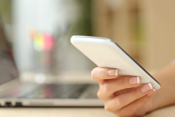 Woman hand using a white smart phone