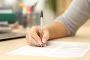 Woman hand writing or signing in a document