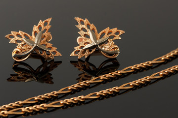 gold necklace and earrings in the form of maple leaves embellish