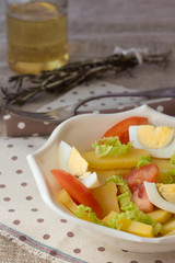 Bowl of potato salad with egg and tomato