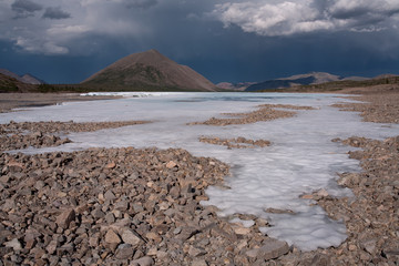 Remains of ice in the valley of a mountain river. Oimyakon Highlands. Labynkyr River. Yakutia.