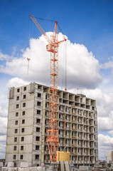 Fototapeta na wymiar Multistorey houses under construction and lifting crane