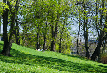 Fototapeta premium Young people relaxing in the park on the grass