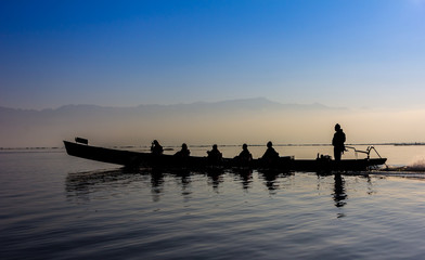 Silhouette of boat at sunset Inle Lake Burma Myanmar