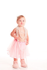 Smiling baby girl 1-2 year old standing over white. Wearing stylish skirt and pearl necklace. Looking at camera. Childhood.