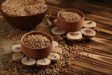 Buckwheat seeds in bowl on a brown wooden table