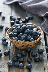 Blueberries in basket on a blue wooden background