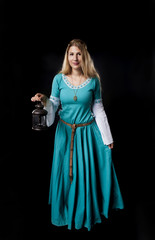 Medieval girl in turquoise dress with a vintage lamp