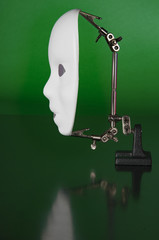 Iron alligator clip stand with white mask on a green background