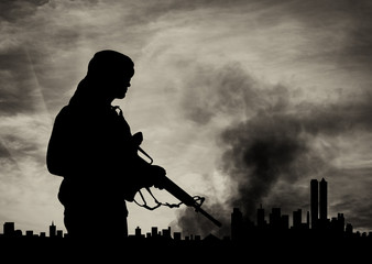 Silhouette of armed man against city in smoke