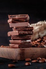 Fresh roasted coffee beans and stack of brown chocolate.