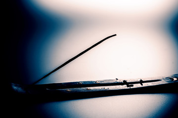 Incense stick on a wooden support on a white background