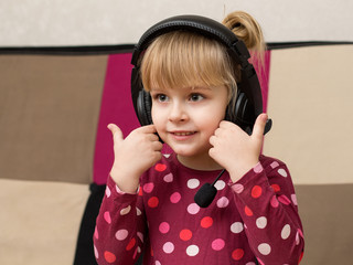 Little blond girl in the headphones smiling