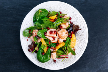 Fresh Salmon Salad with vegetables, pomegranate and orange.