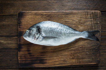 Fresh catch whole fish on wooden board
