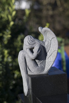 der Engel sitzt auf dem Grabstein