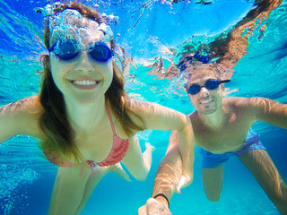 Couple in love refreshing underwater on vacation. Diving. Wide angle selfie shot.