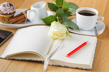 rose and empty notebook page on wood background