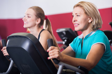 Fototapeta premium Women training on exercise bikes together
