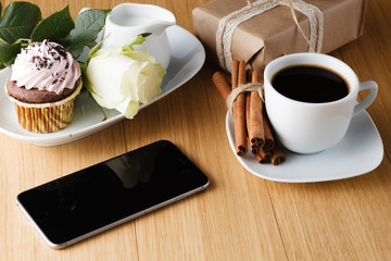 Cup of coffee with notebook and mobile phone