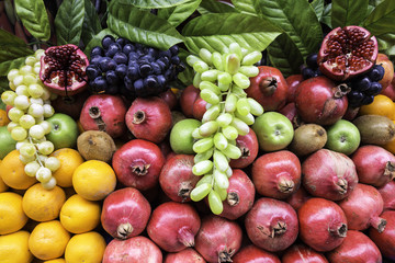 Many kind of different fruits on a showcase closeup view. Street vendor selling colorful exotic fruits and fruit juice.