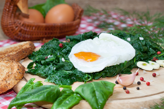 Fried egg on spinach with garlic and pepper