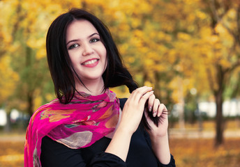 beautiful girl in black dress and red scarf in yellow city park, fall season