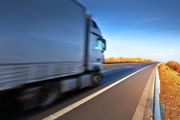 White truck driving through the autumn landscape