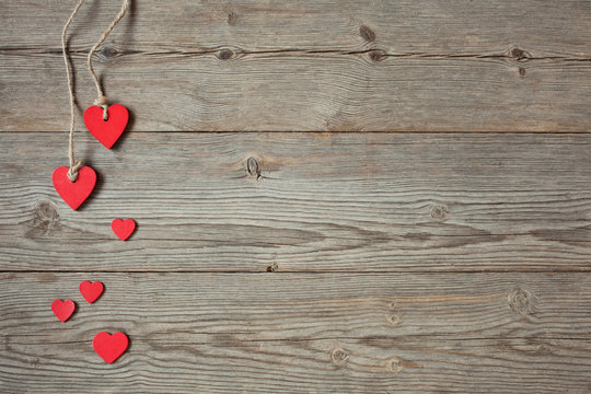Wooden background with red hearts