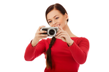 Pretty woman taking a photo using classic slr camera