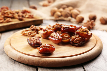 Walnut, date fruit on wooden table, close-up