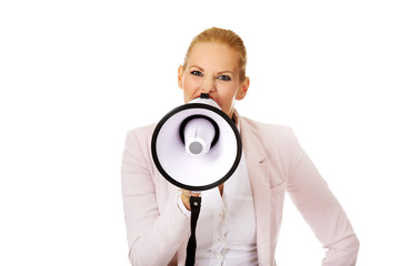 Young business woman screaming through megaphone
