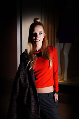 Beautiful stylish young woman walking on the street at night