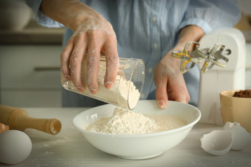 Woman is adding flour to the mixture