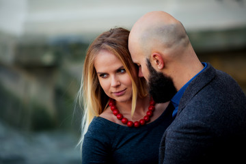 Obraz premium happy couple smiling, standing near the wall in the arms