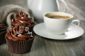 Chocolate cupcakes served with coffee on wooden table