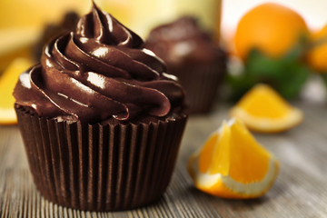 Chocolate cupcakes served with orange on a table