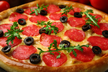 Tasty pizza with salami and red vegetables on wooden background, close up